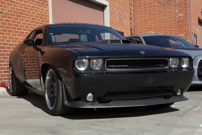 Black Dodge Challenger in front of brick building