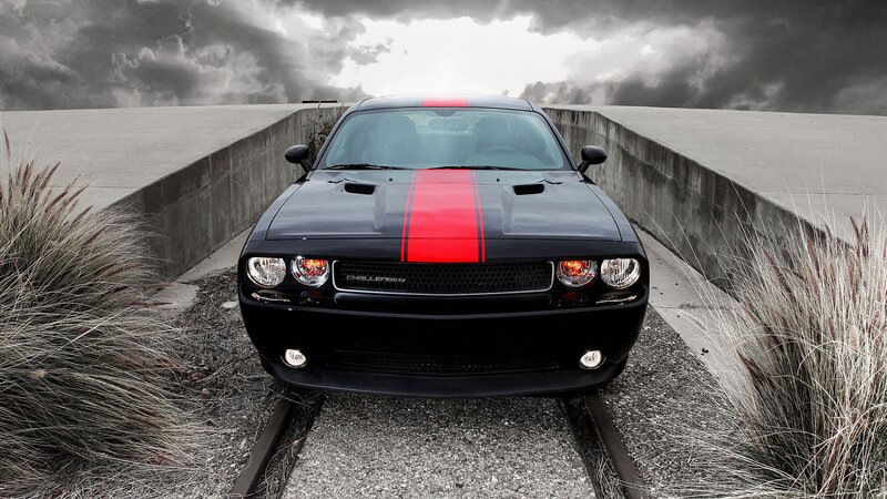 Black Dodge Challenger on train tracks