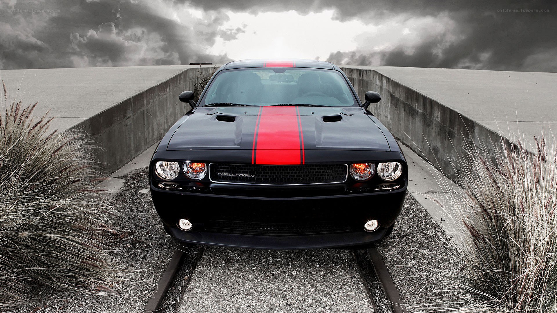Black Dodge Challenger on train tracks