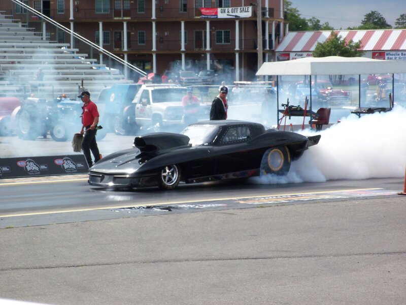 Black drag car burning rubber