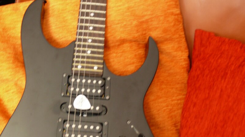 black electric guitar on orange fabric