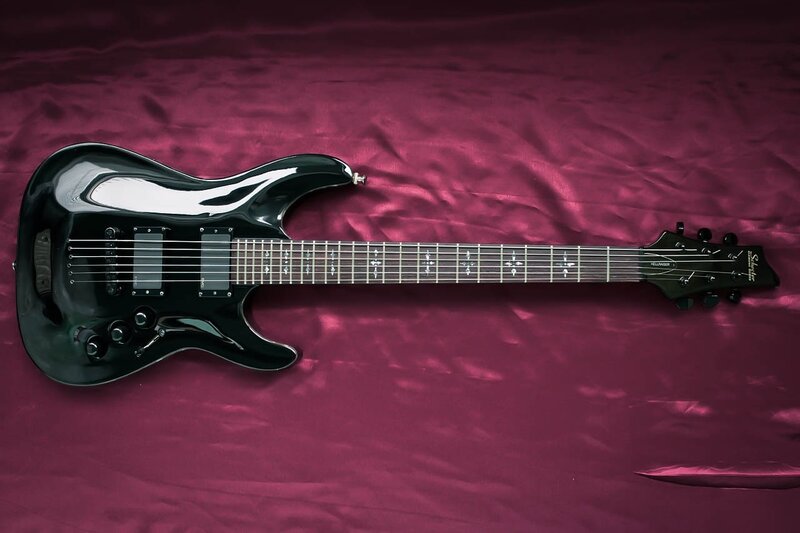 black electric guitar on purple cloth