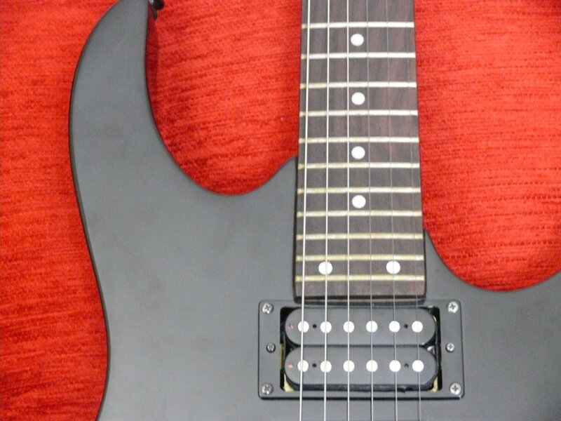 black electric guitar on red
