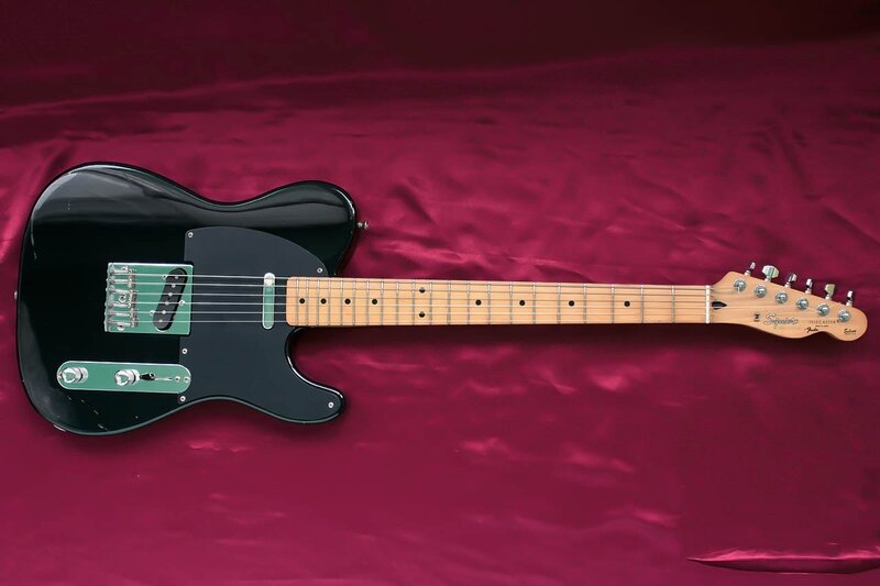 black electric guitar on red cloth