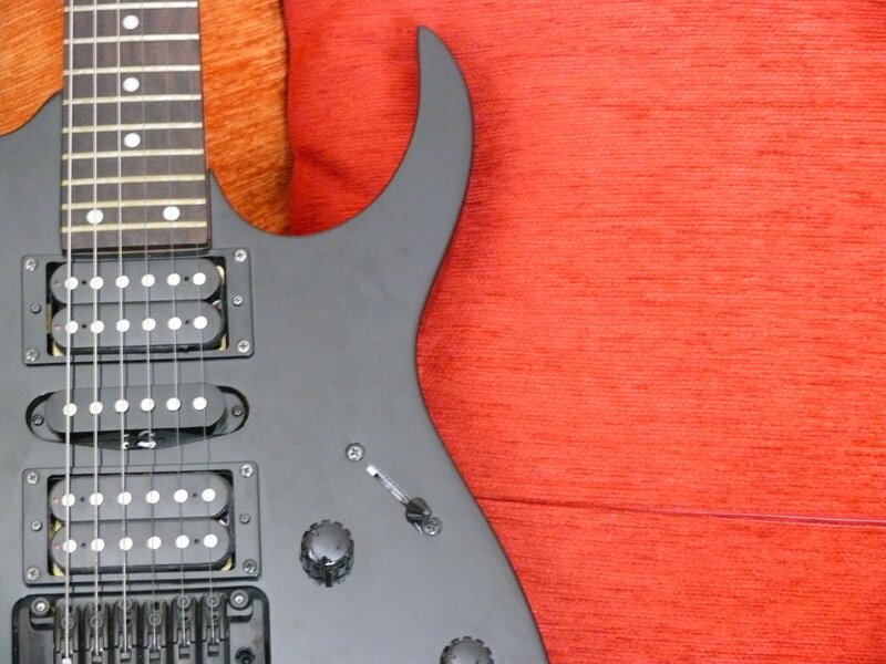 black electric guitar on red fabric