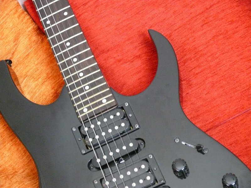 black electric guitar on red fabric