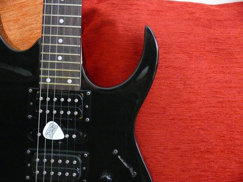 black electric guitar on red fabric