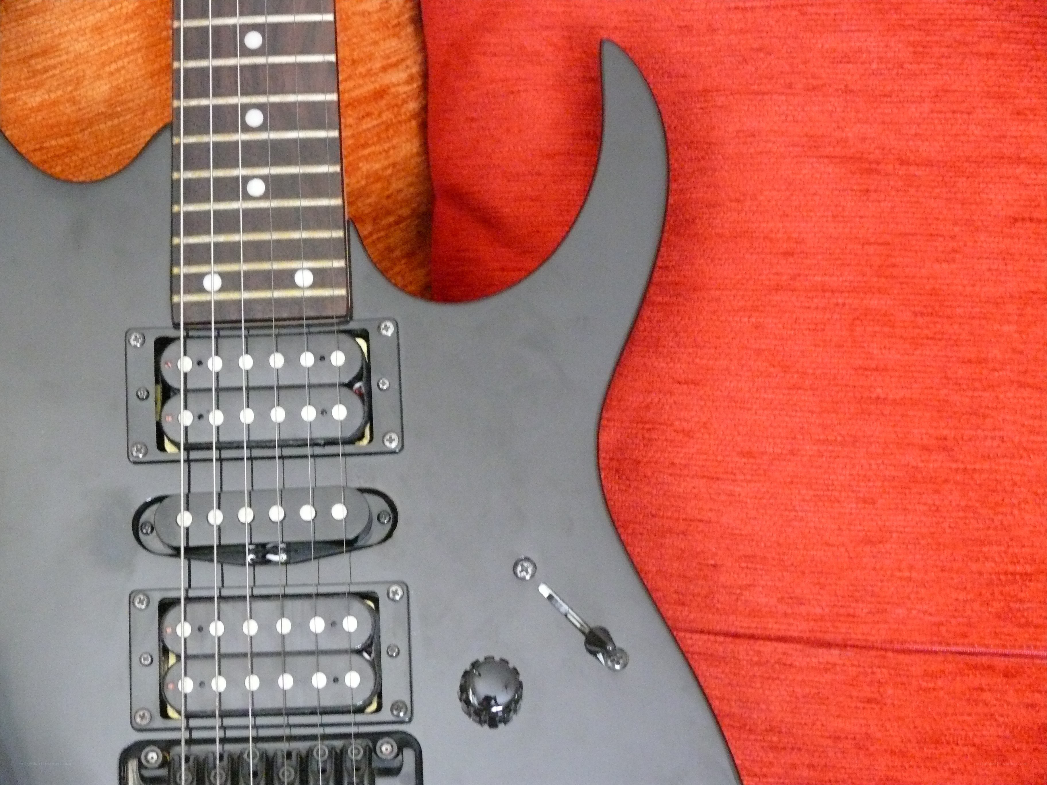 black electric guitar on red