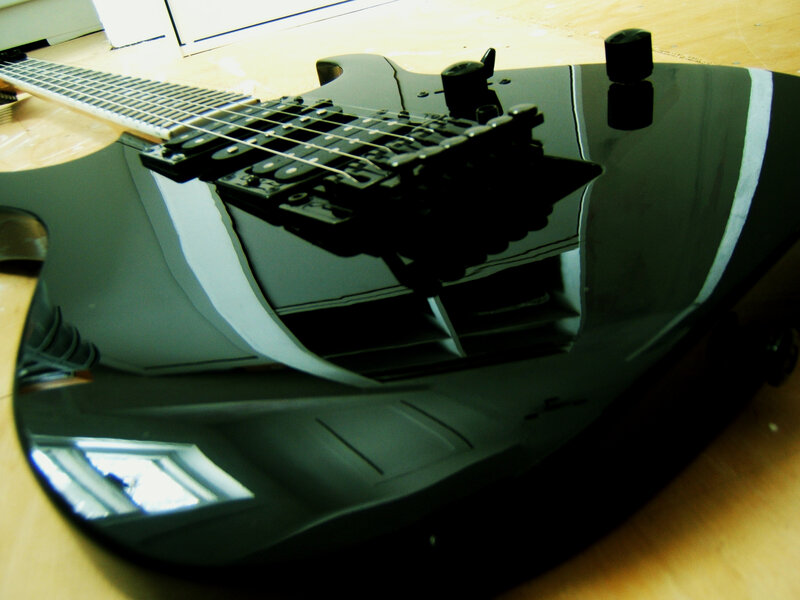black electric guitar on wood