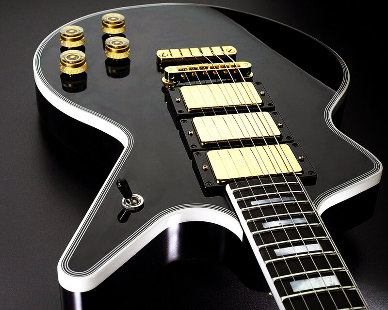 black electric guitar with gold hardware