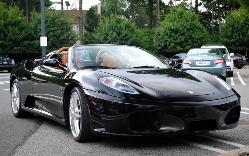 Black Ferrari convertible in parking lot