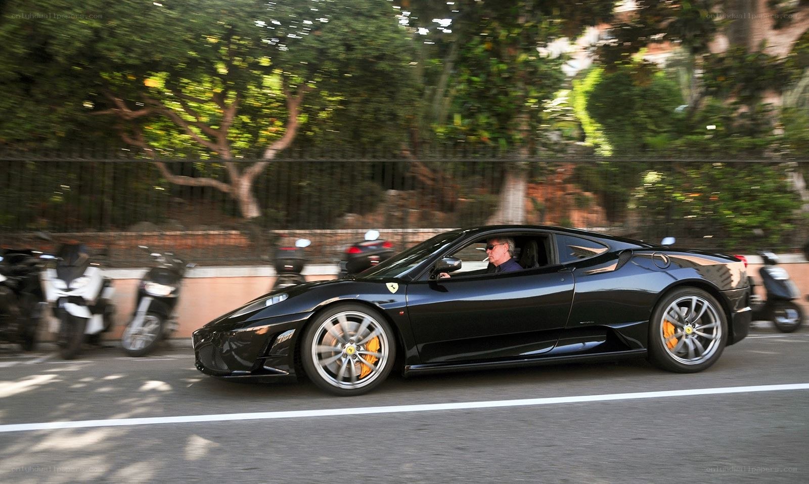 Black Ferrari driving on a street