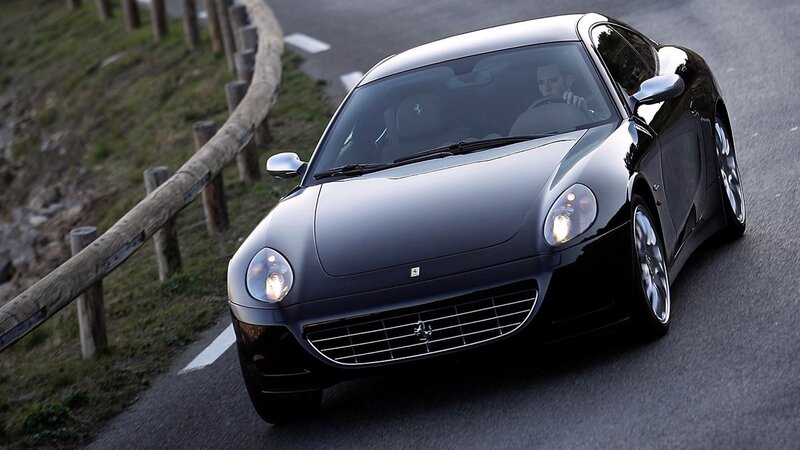 Black Ferrari driving on road