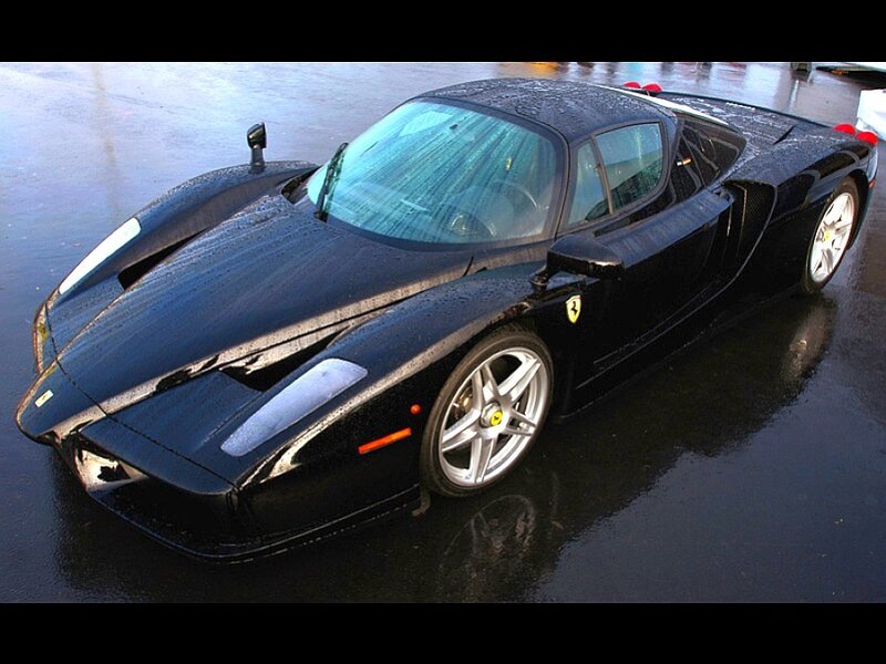 Black Ferrari Enzo on wet pavement