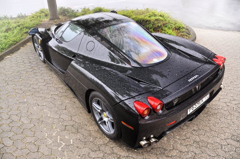 Black Ferrari Enzo on wet pavement