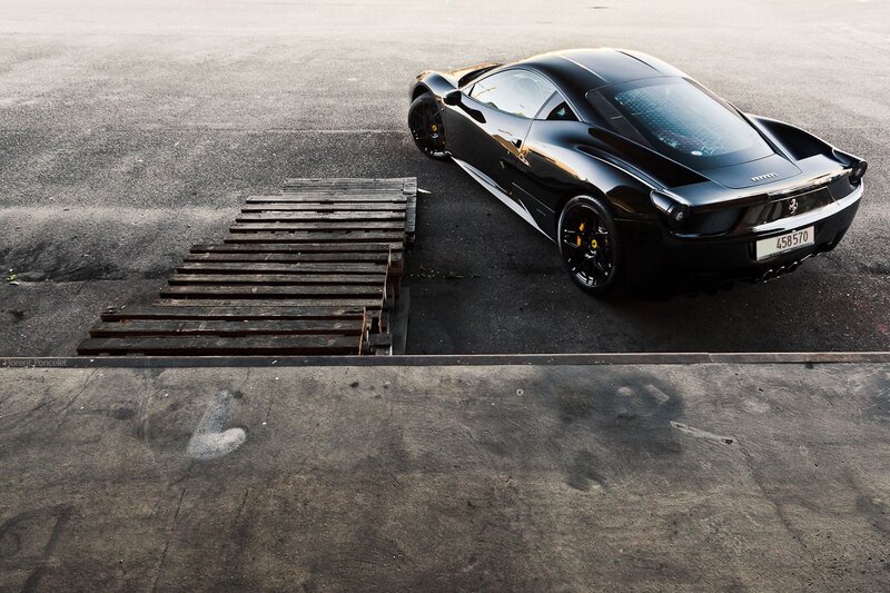 Black Ferrari on a concrete lot