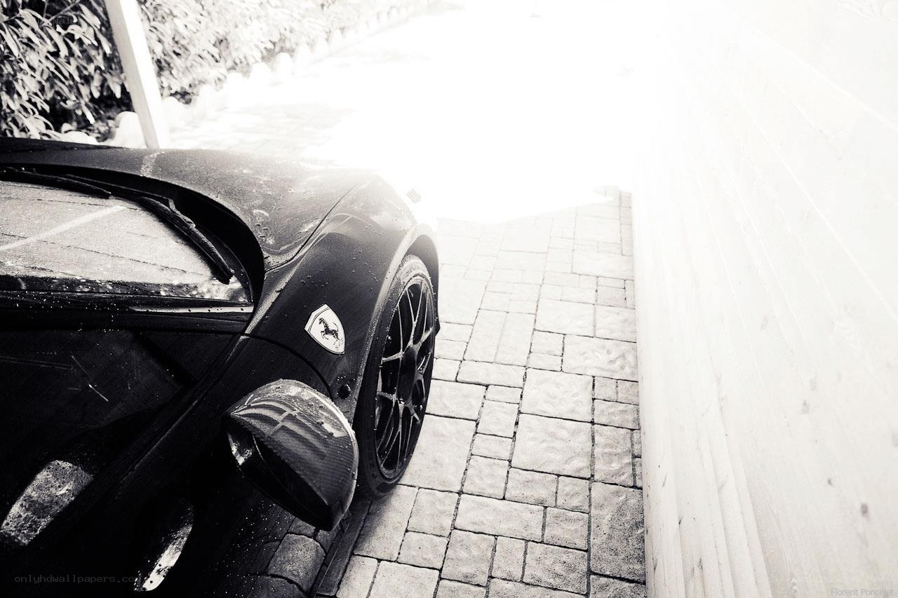 Black Ferrari on a stone driveway