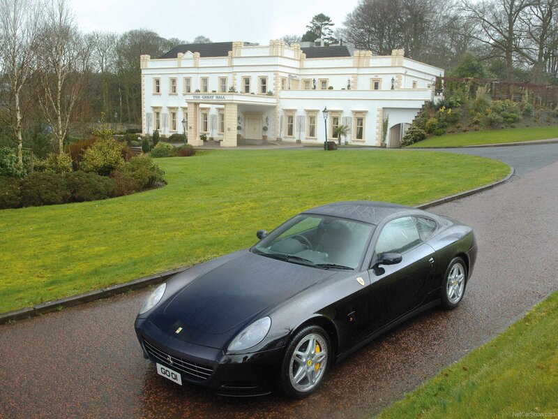 Black Ferrari parked in front of a mansion
