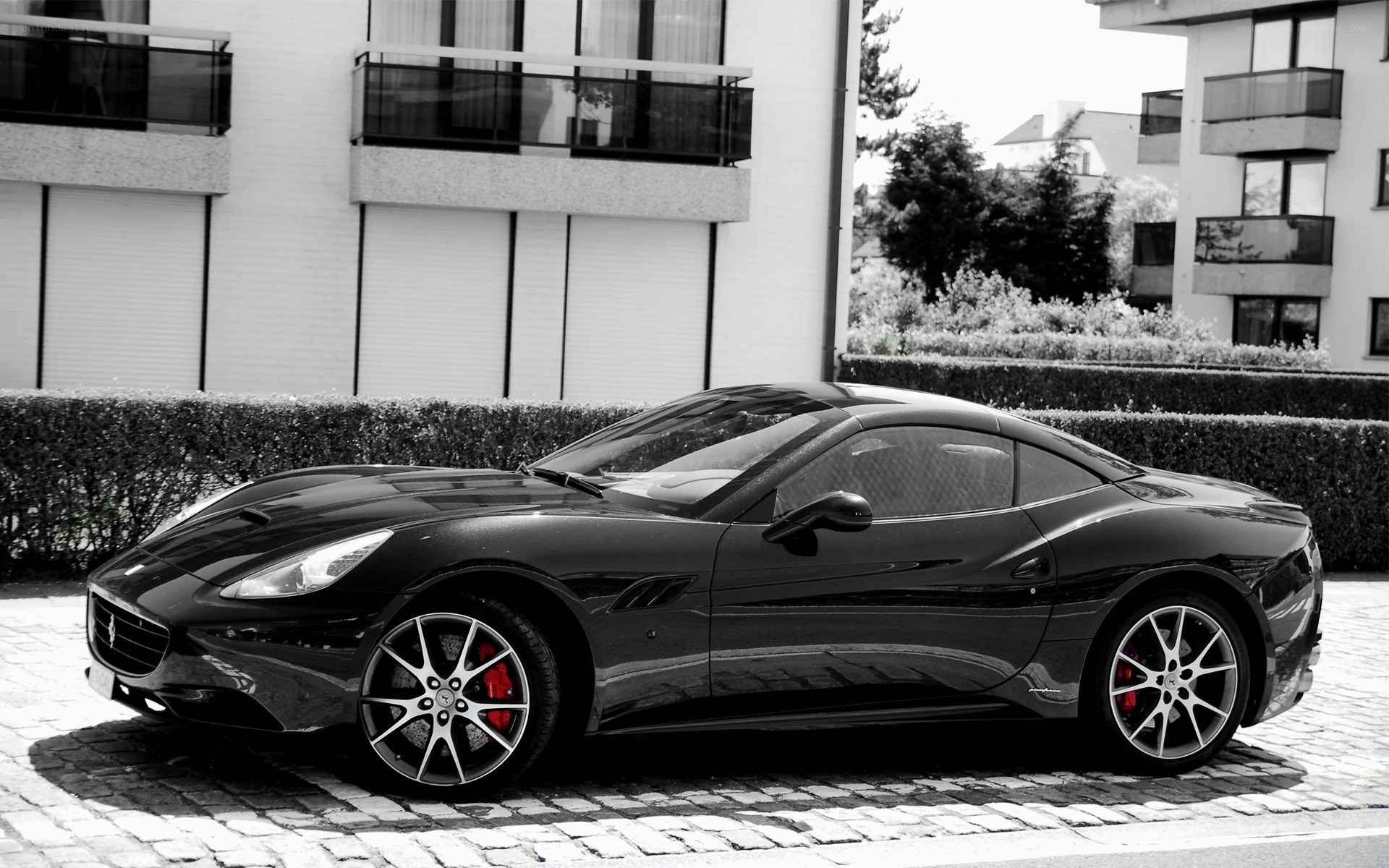 Black Ferrari parked on cobblestones