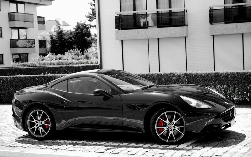 Black Ferrari parked on cobblestones