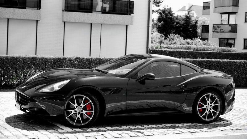 Black Ferrari parked on cobblestones