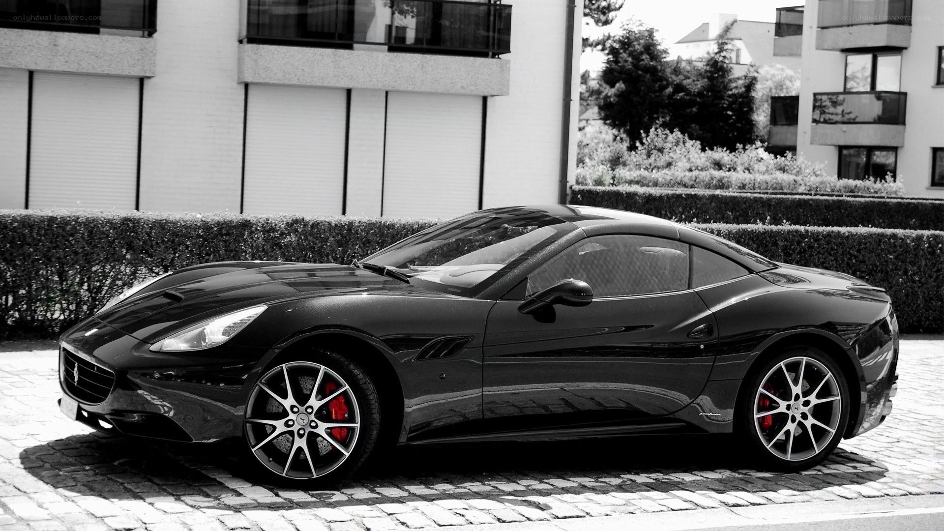 Black Ferrari parked on cobblestones