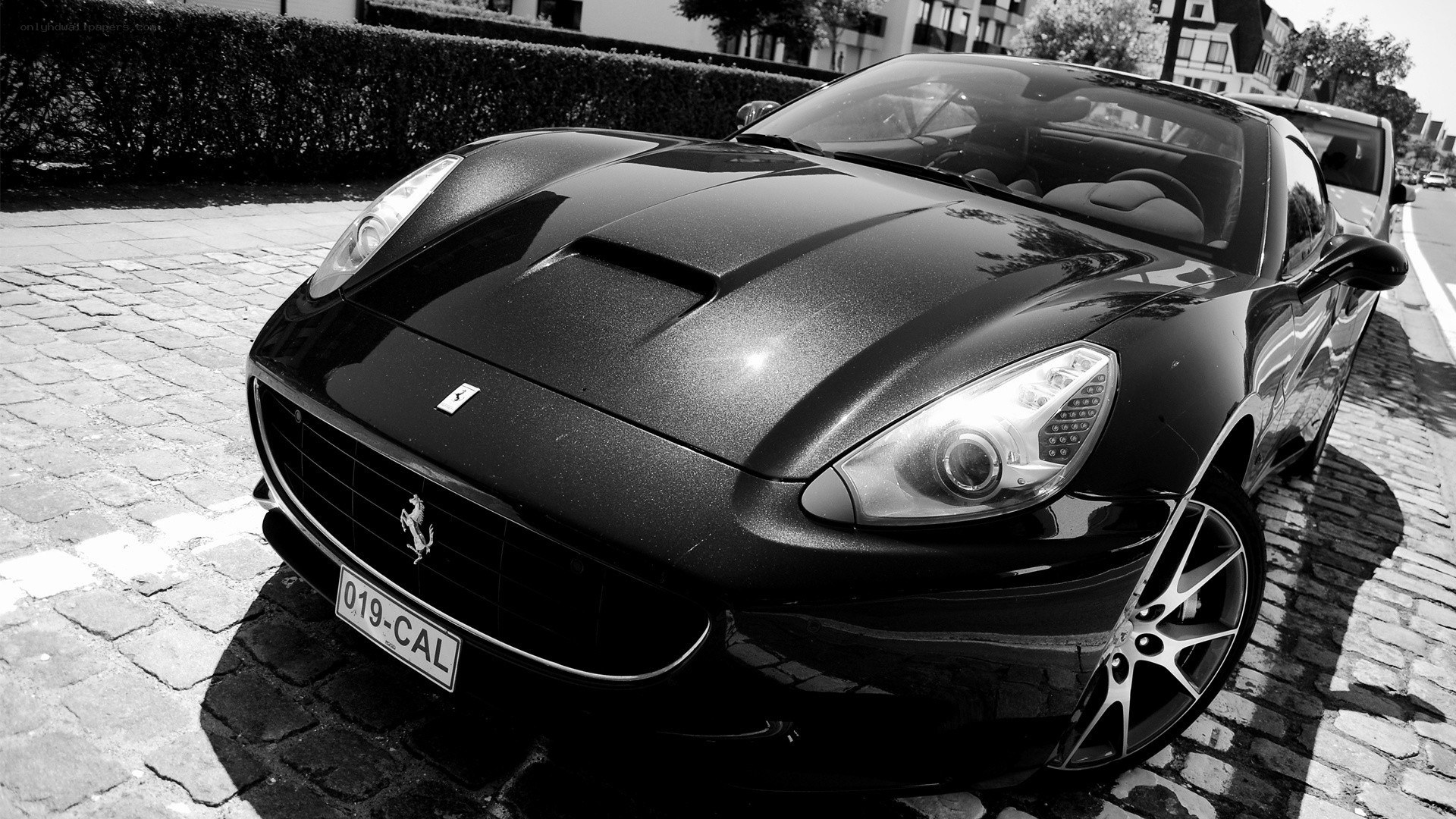 Black Ferrari parked on cobblestones