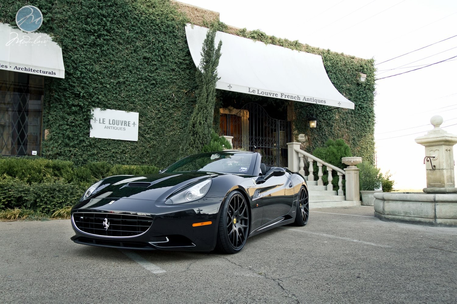 Black Ferrari parked outside shop