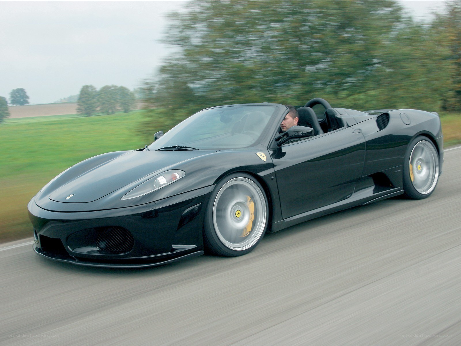 black ferrari roadster in motion