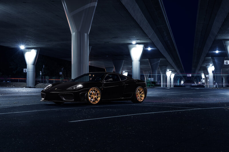 Black Ferrari under highway at night