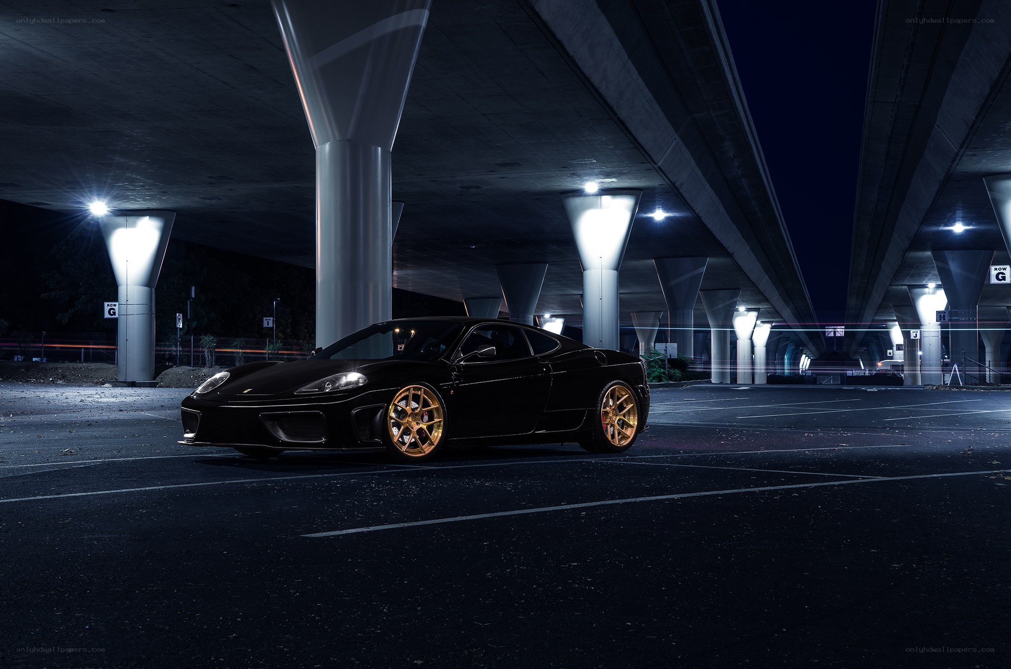 Black Ferrari under highway at night