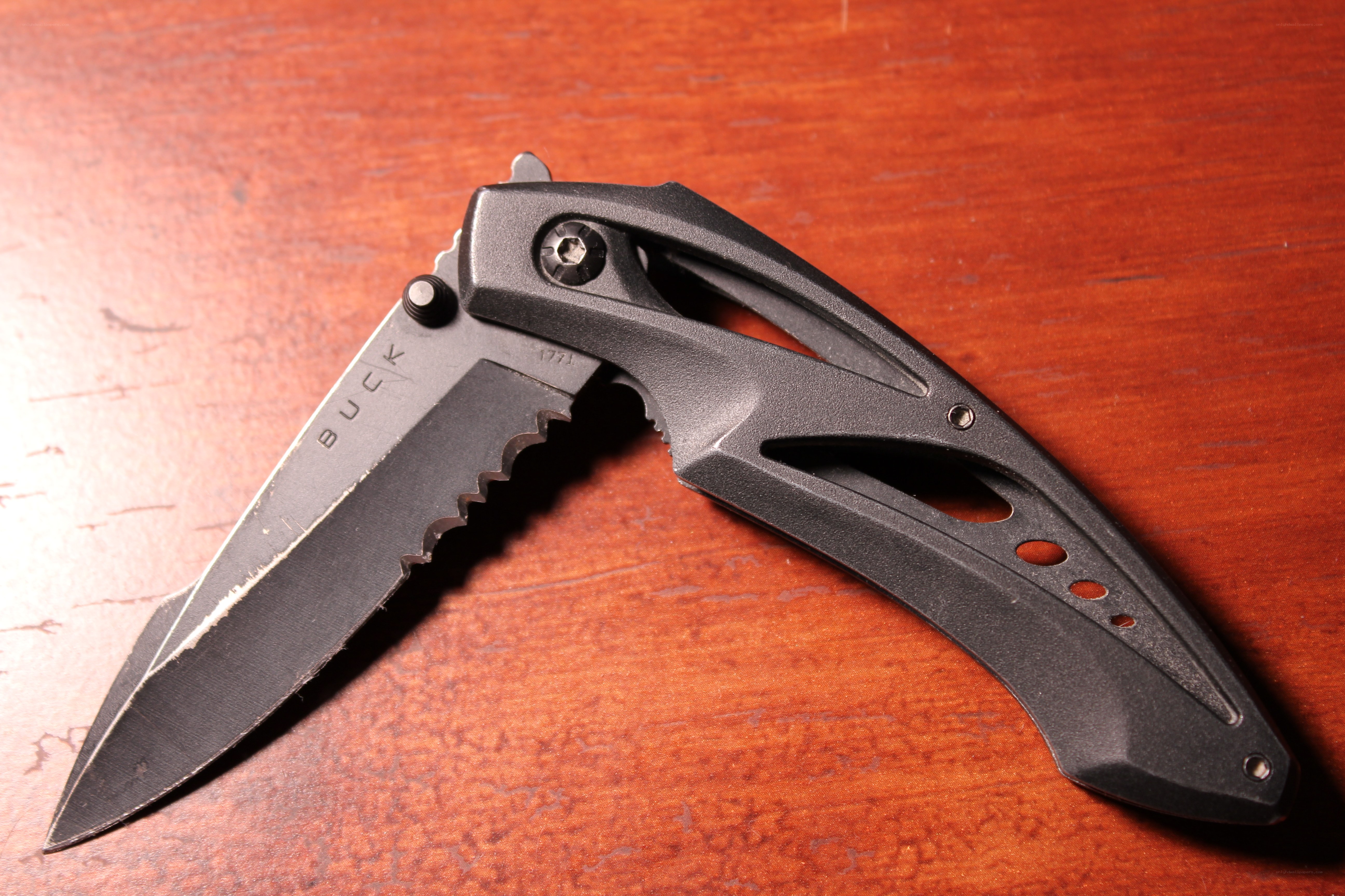 black folding knife on wood