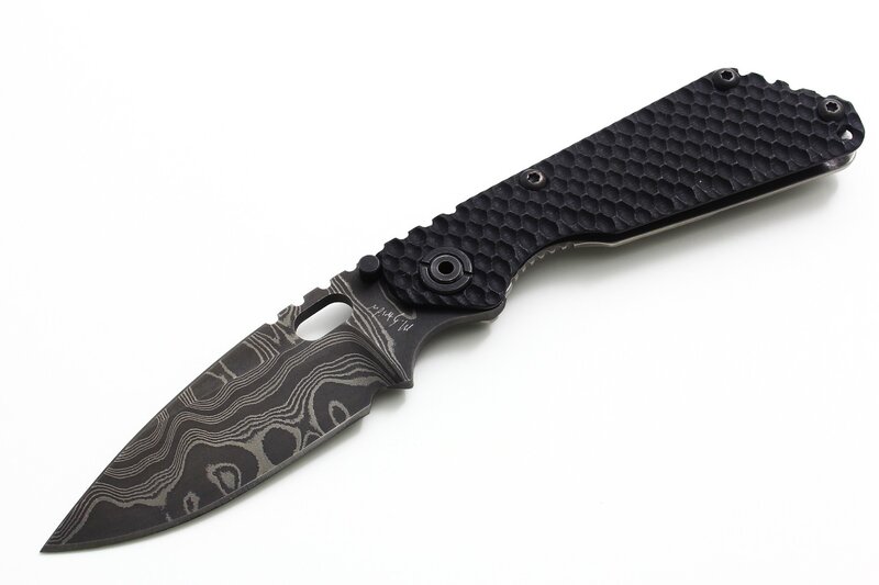 black folding knife with patterned blade
