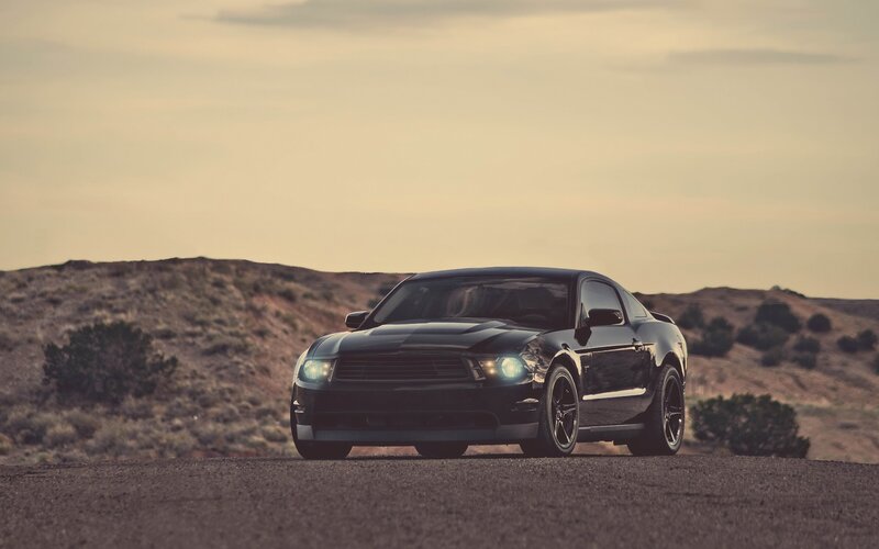 Black Ford Mustang on desert road