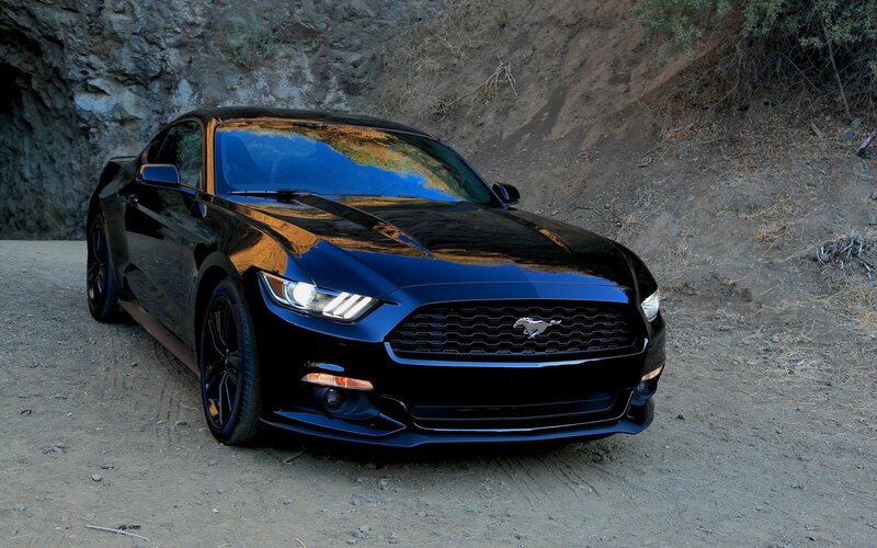 Black Ford Mustang on dirt road