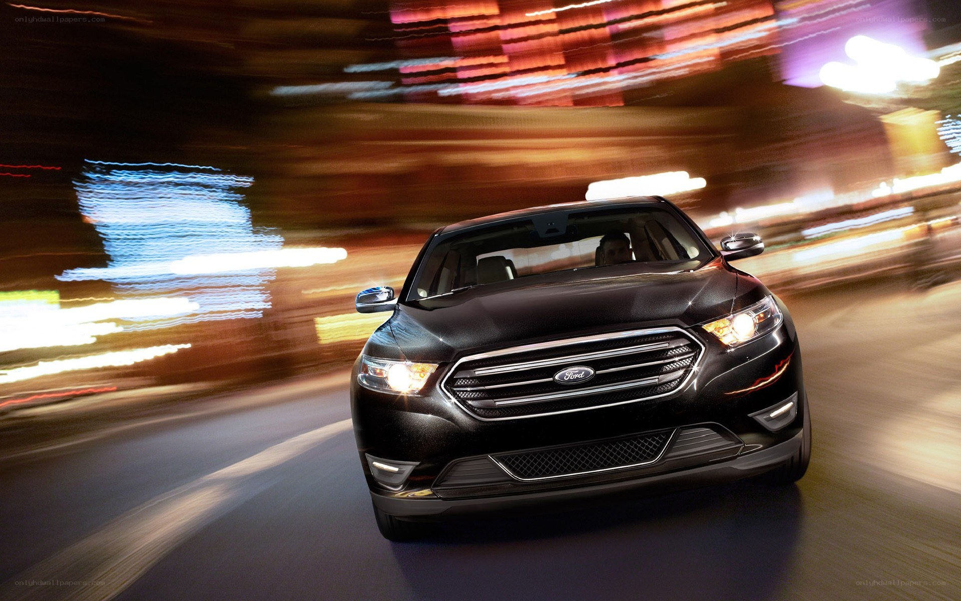 Black Ford Taurus in motion