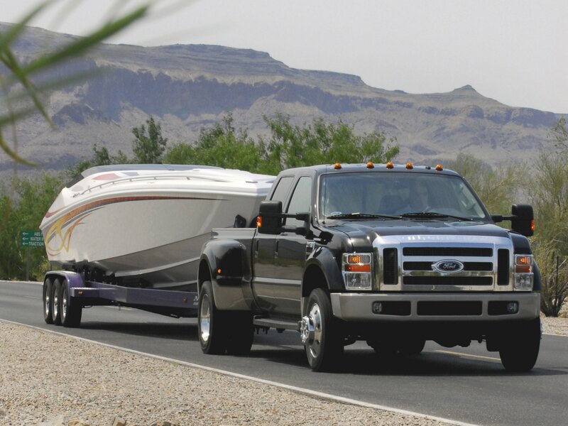 Black Ford truck towing boat