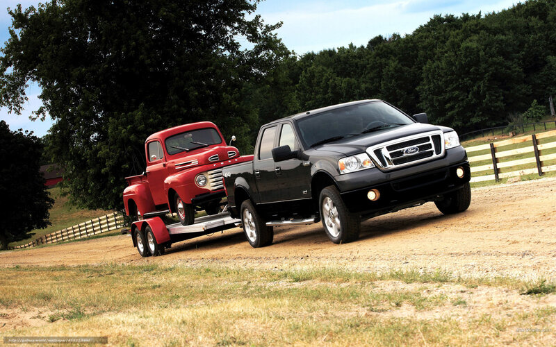 Black Ford truck towing vintage red truck