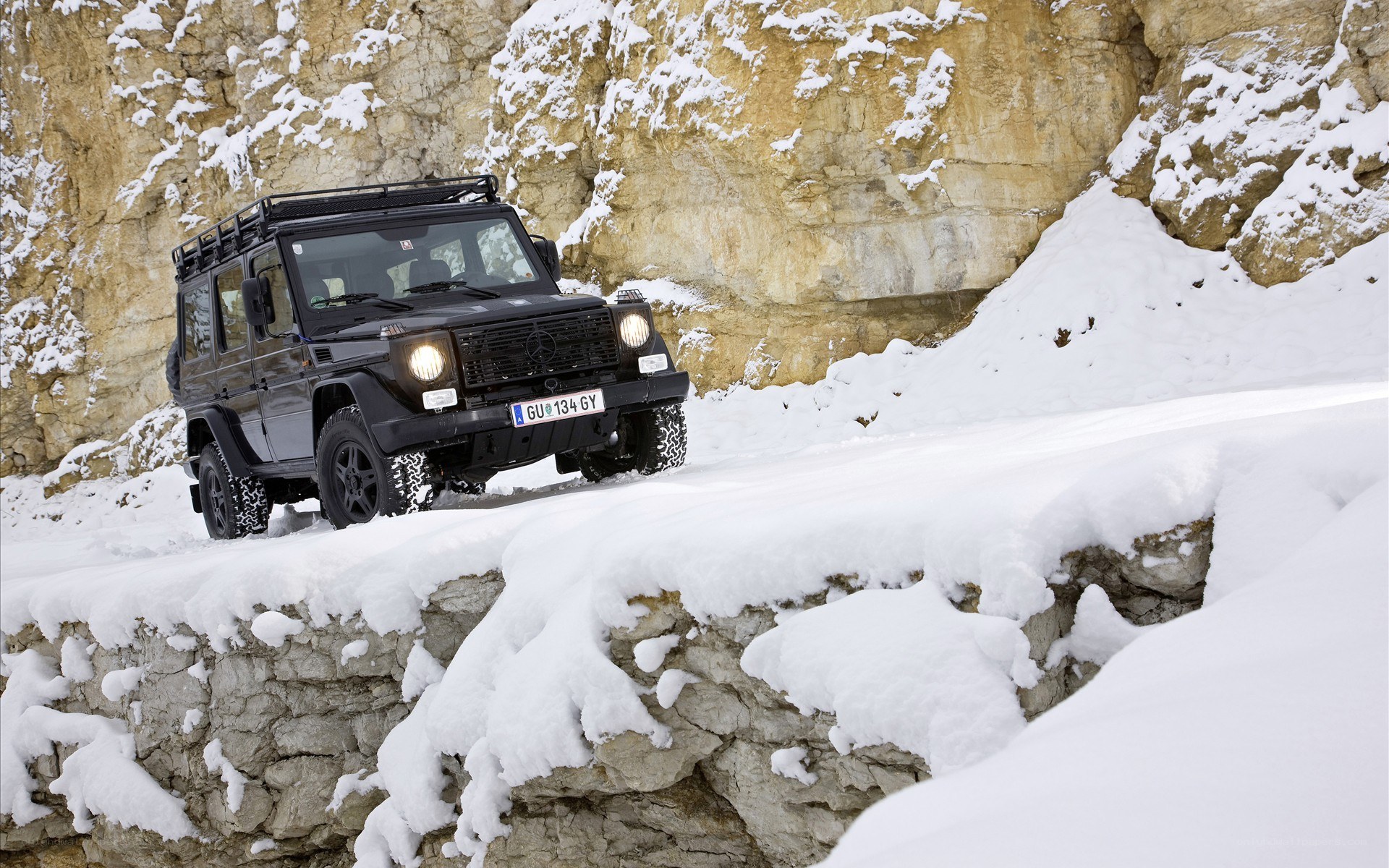 Black G-Wagon on snowy cliff