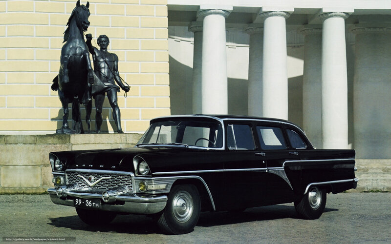 Black GAZ-13 car in front of statue