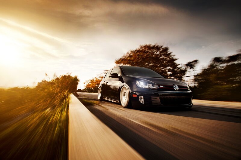 Black GTI on a road at sunset