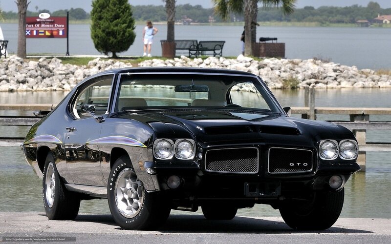 Black GTO muscle car by water