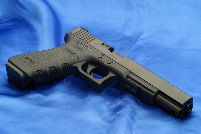 Black Handgun on Blue Cloth — Neutral, Photograph