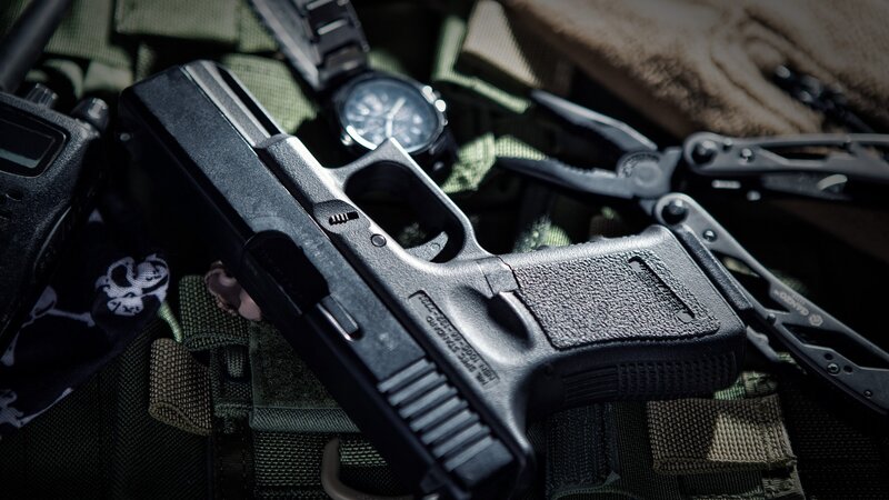 Black Handgun on Gear — Dramatic