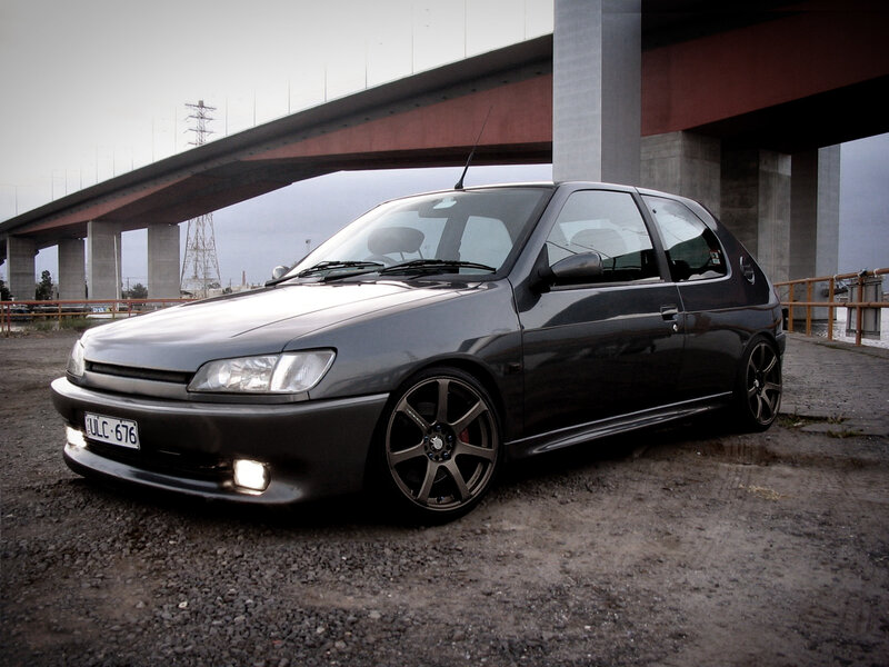 black hatchback under a bridge