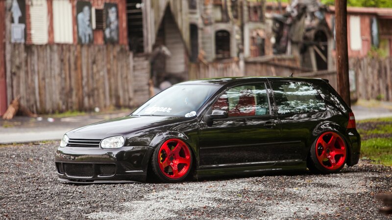 black hatchback with red wheels