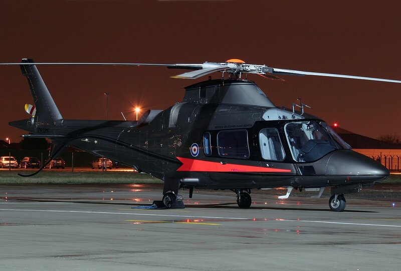 Black helicopter on tarmac at night