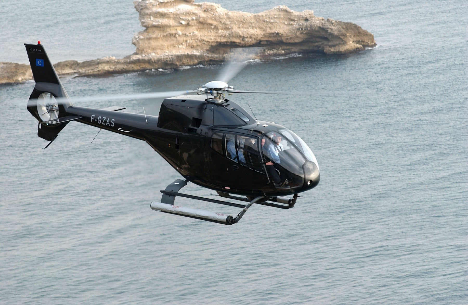 Black helicopter over the sea