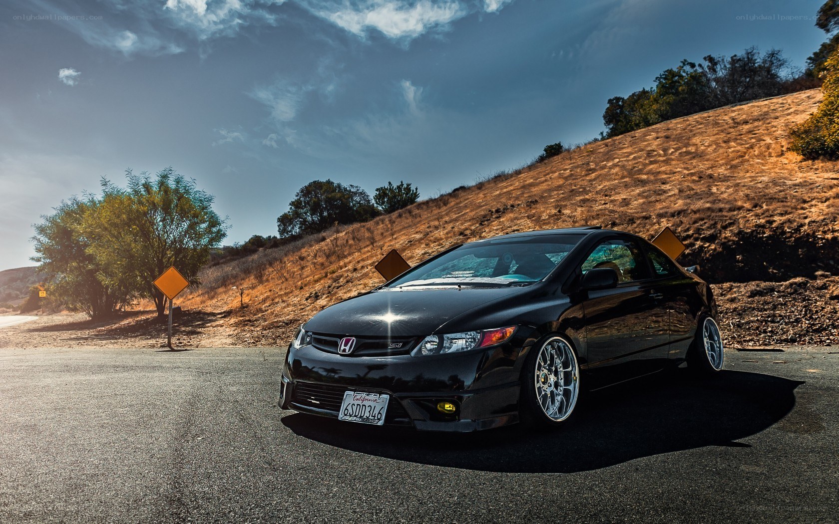 Black Honda Civic on a hillside road
