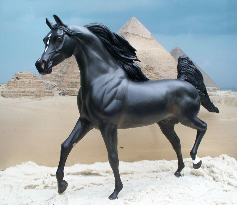 Black horse figurine in desert